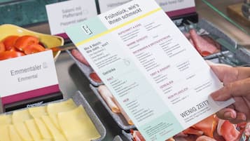 A menu with various food options and a hand holding it.