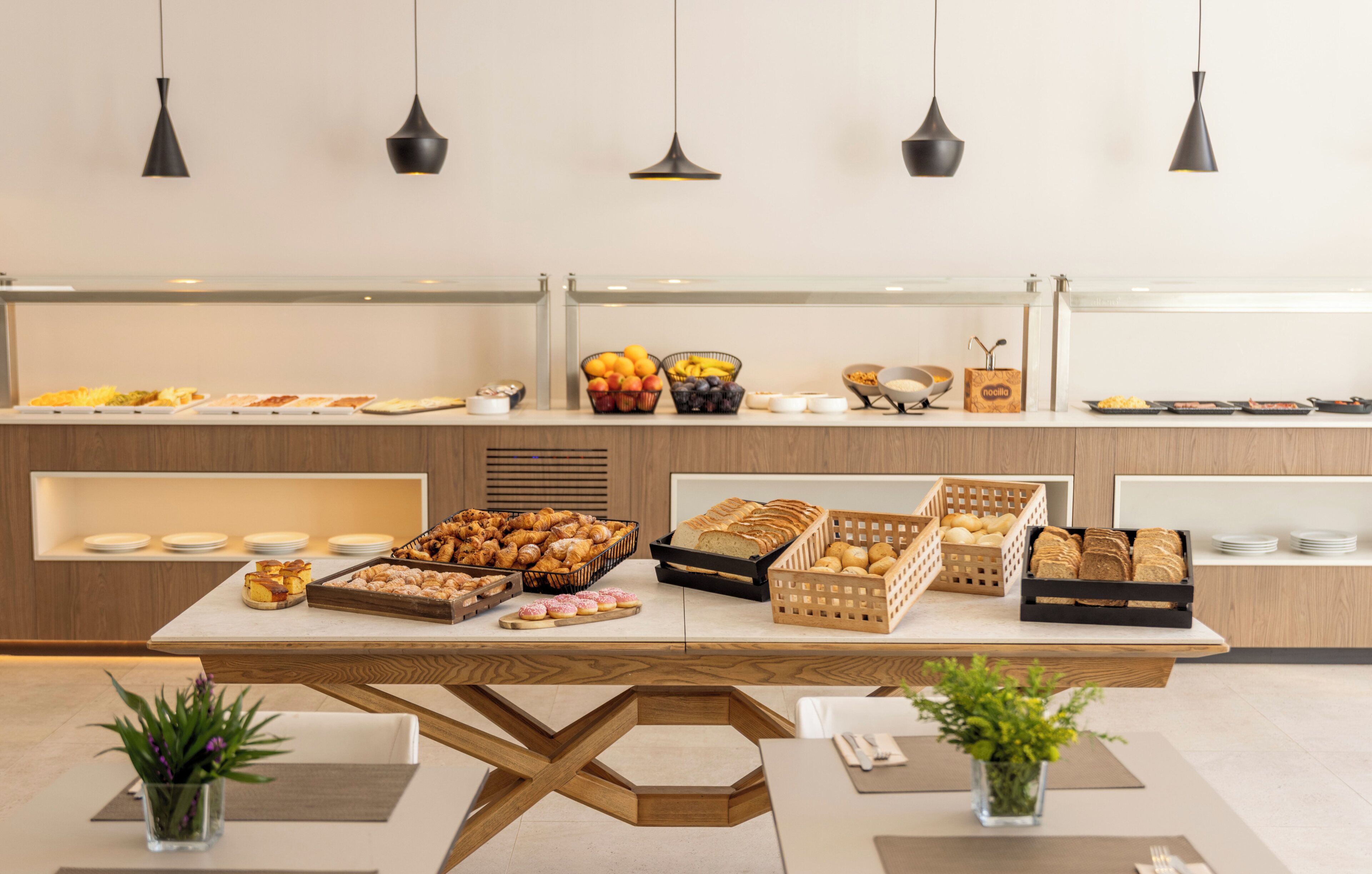 A buffet setup with various food items and a table with chairs.
