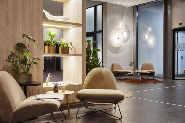 Relax in our inviting lobby, featuring a reception desk, plush armchairs, and a spacious seating area.