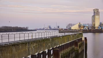Ein Industriegebiet am Wasser mit einer Betonbrücke, Wasser und Industriegebäuden.