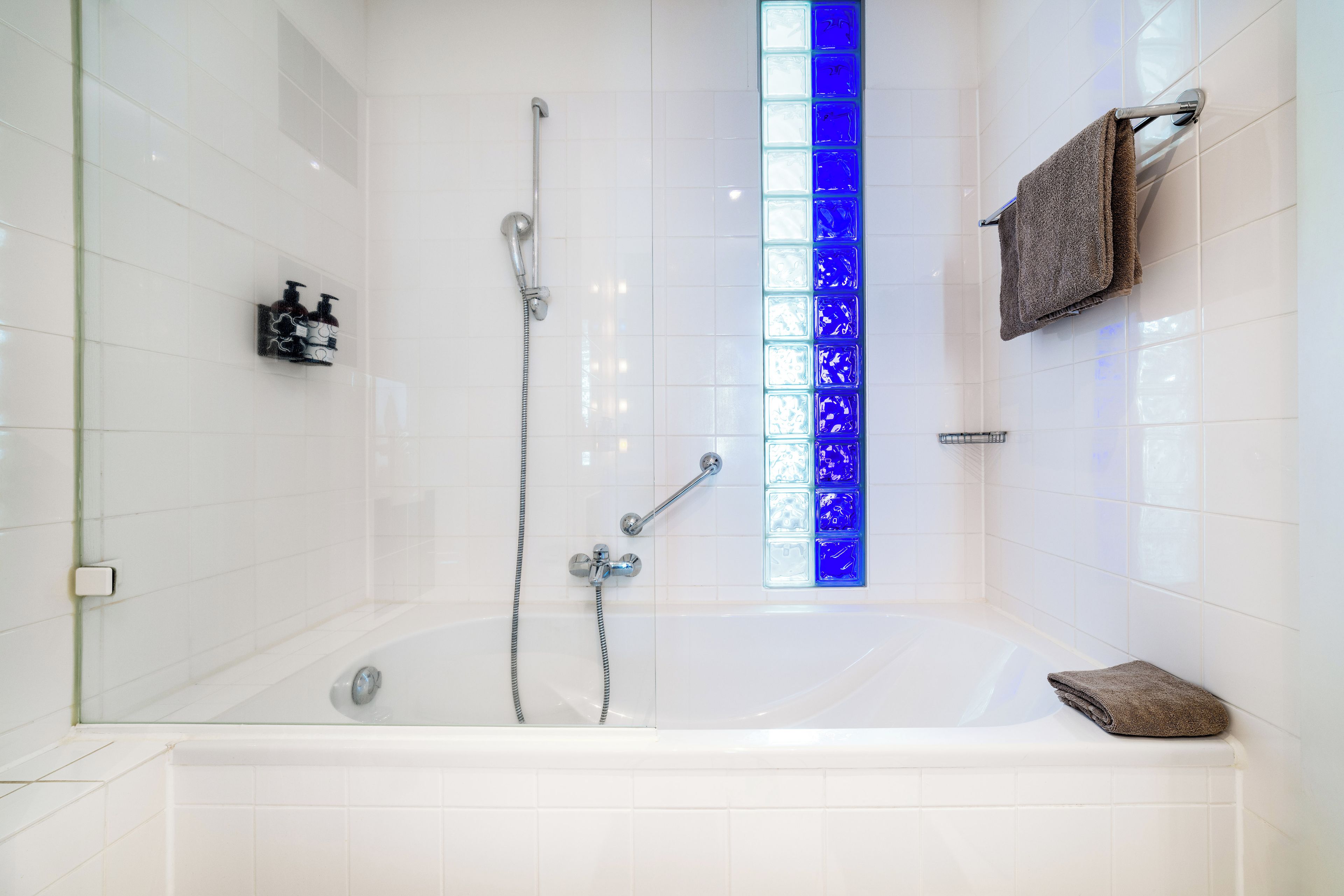 Een badkamer met een bad, een douche en een douchecabine van glas.
