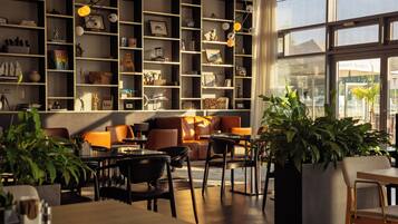 A modern interior with a seating area, tables, and a large window.