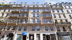 A multi-story building with a classic European architectural style, featuring ornate balconies and a central entrance. - Hotel Altona (Paris)