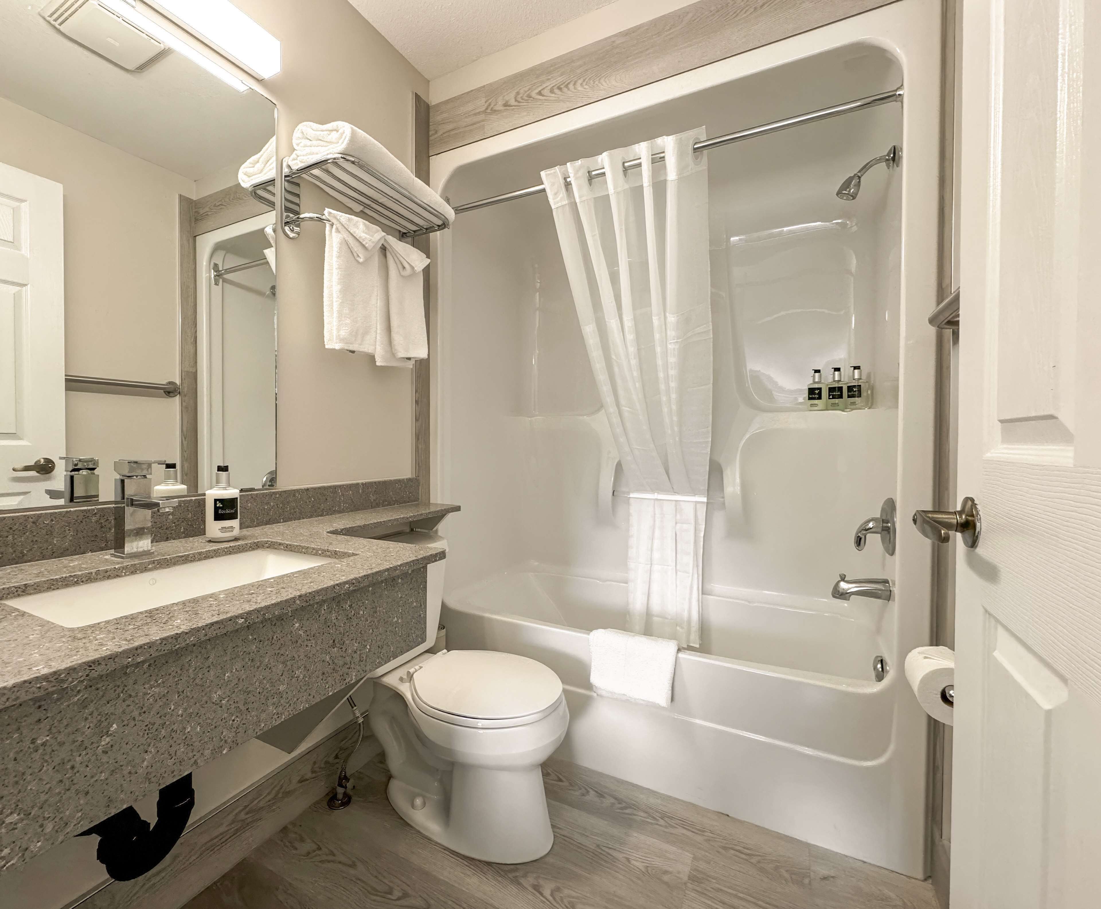 Un baño moderno con bañera, inodoro y tocador.
