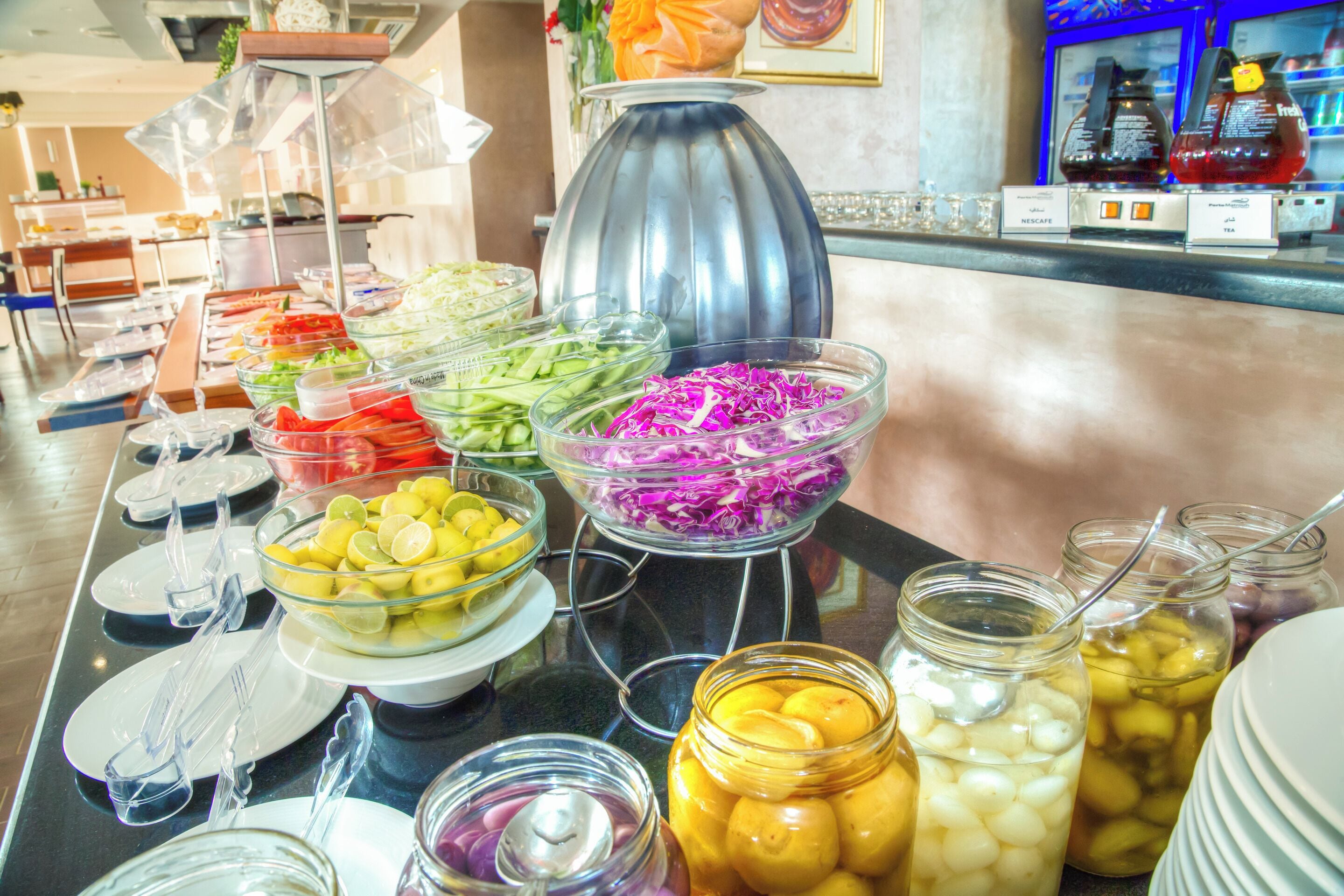 A buffet table with various food items and condiments.