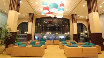 A lobby with multiple seating areas, a reception desk, and large windows.