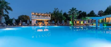 Una piscina al aire libre de temporada, sombrillas