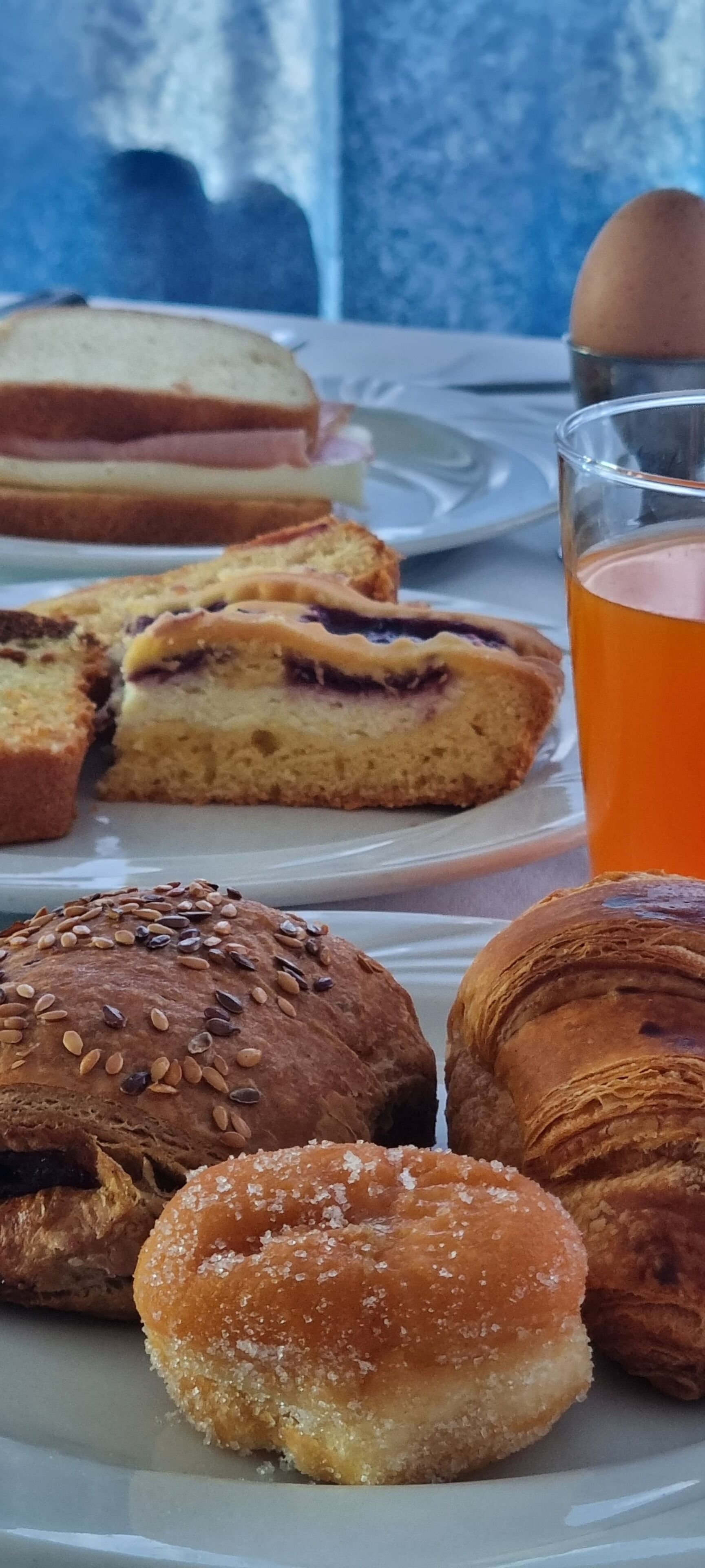 Un plato con pasteles y un vaso de jugo de naranja.