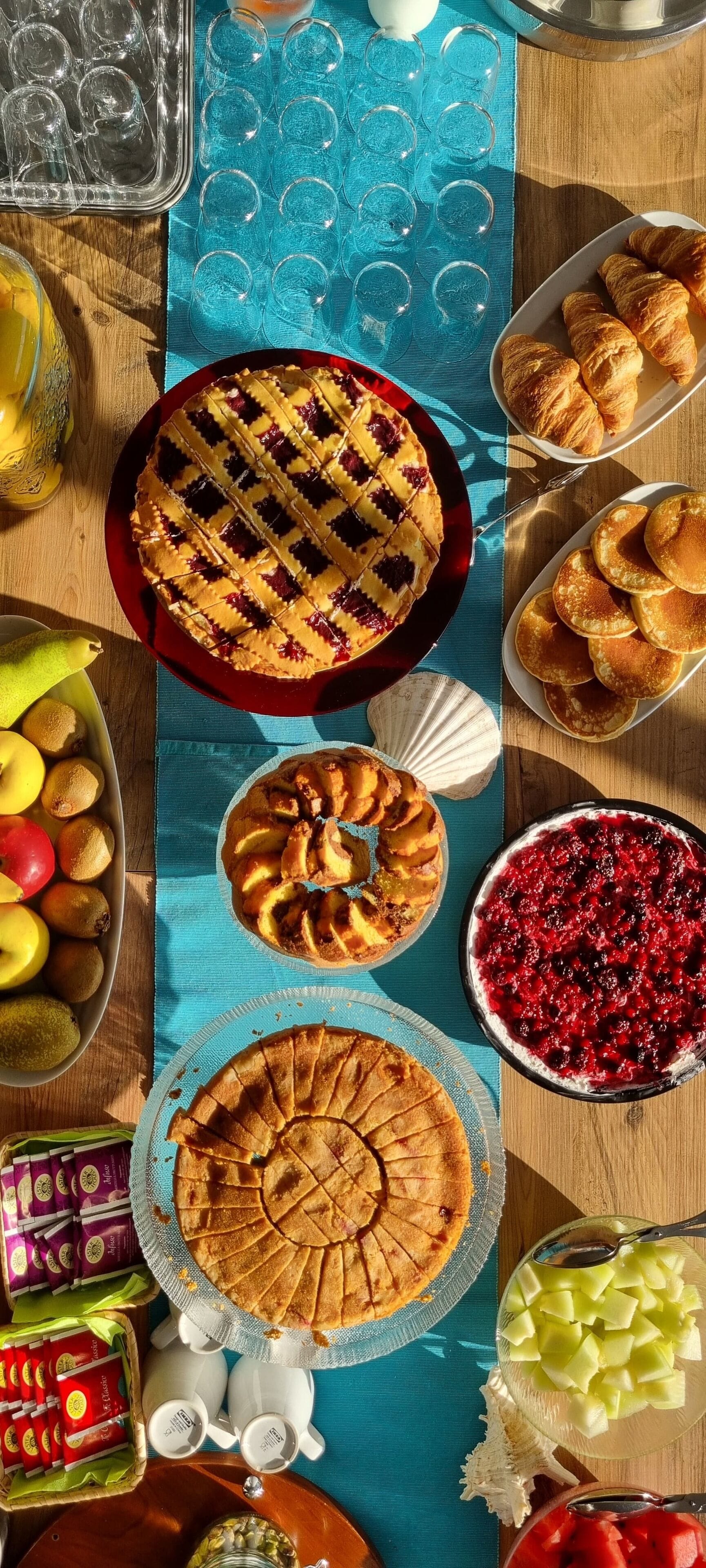 A table with various food items including pies, pastries, and fruit.