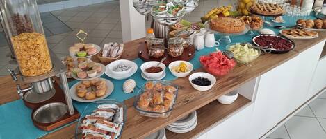 A buffet table with various food items and a coffee station.