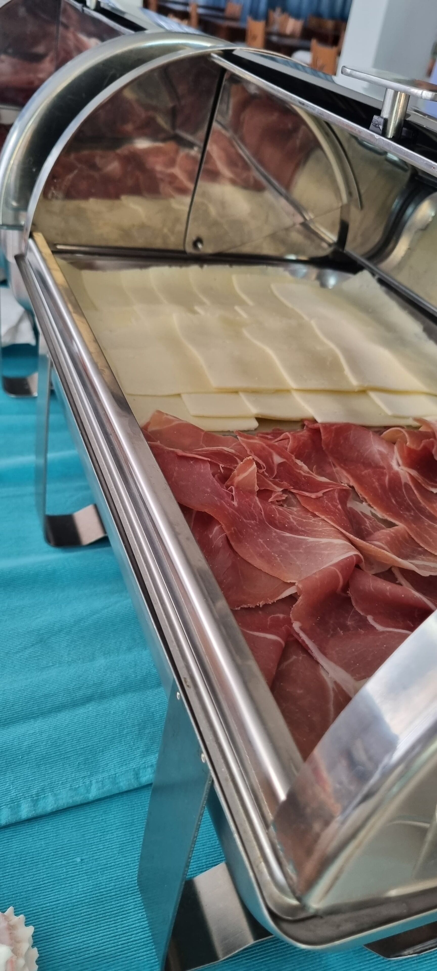 A meat display case with various cuts of meat and cheese.