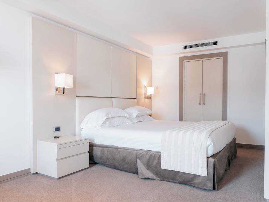Un dormitorio moderno con cama, mesitas de noche y armario.