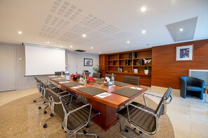 Meet for business in a well-equipped conference room with a large table, comfortable chairs, and a whiteboard for brainstorming.