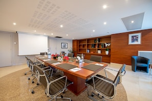 Meet for business in a well-equipped conference room with a large table, comfortable chairs, and a whiteboard for brainstorming.