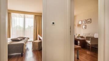Una camera d'albergo con un letto, un tavolino, una divano e un'area da pranzo.