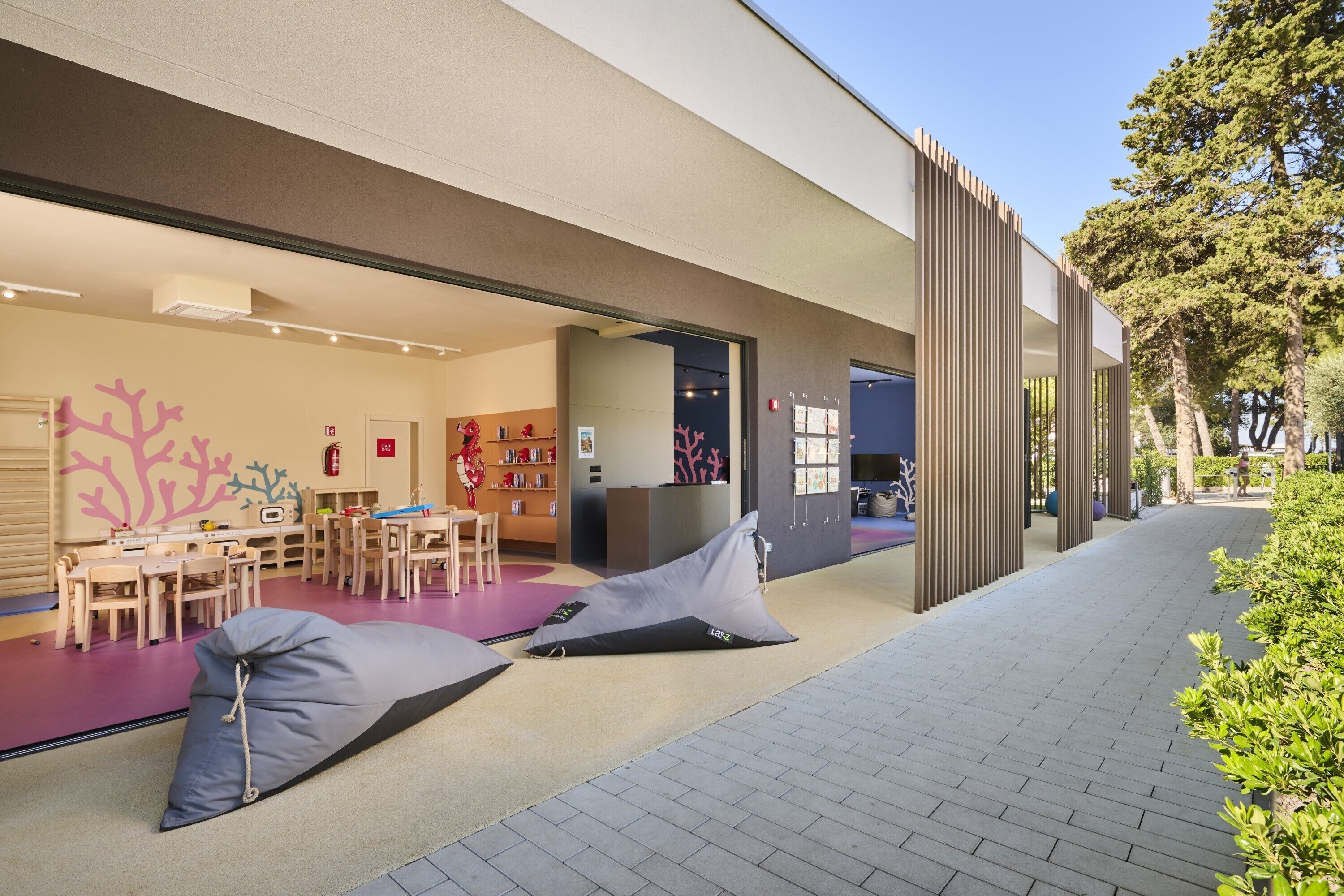 An outdoor seating area with bean bags and a children's play area with tables and chairs.