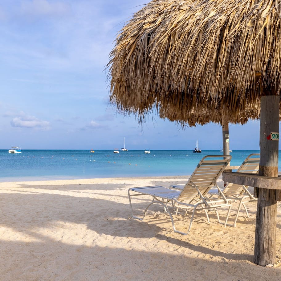 On the beach, white sand, beach cabanas, sun loungers