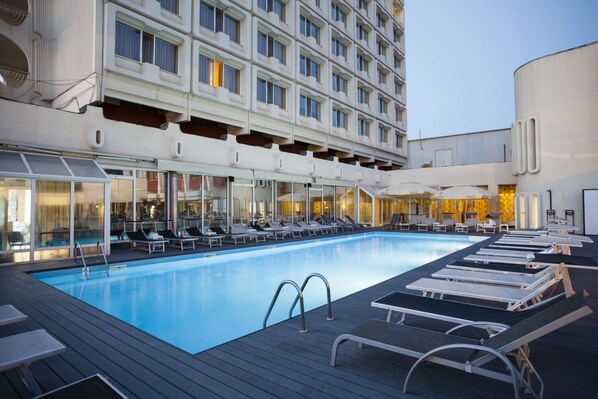 A swimming pool with lounge chairs and a building with balconies in the background. - North Star Continental Resort (Timisoara)