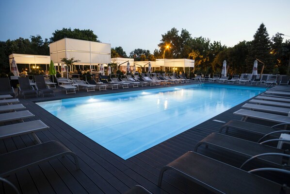Una piscina cubierta, una piscina al aire libre de temporada, sombrillas