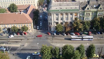 Een stadsstraat met gebouwen, auto's en een tram.