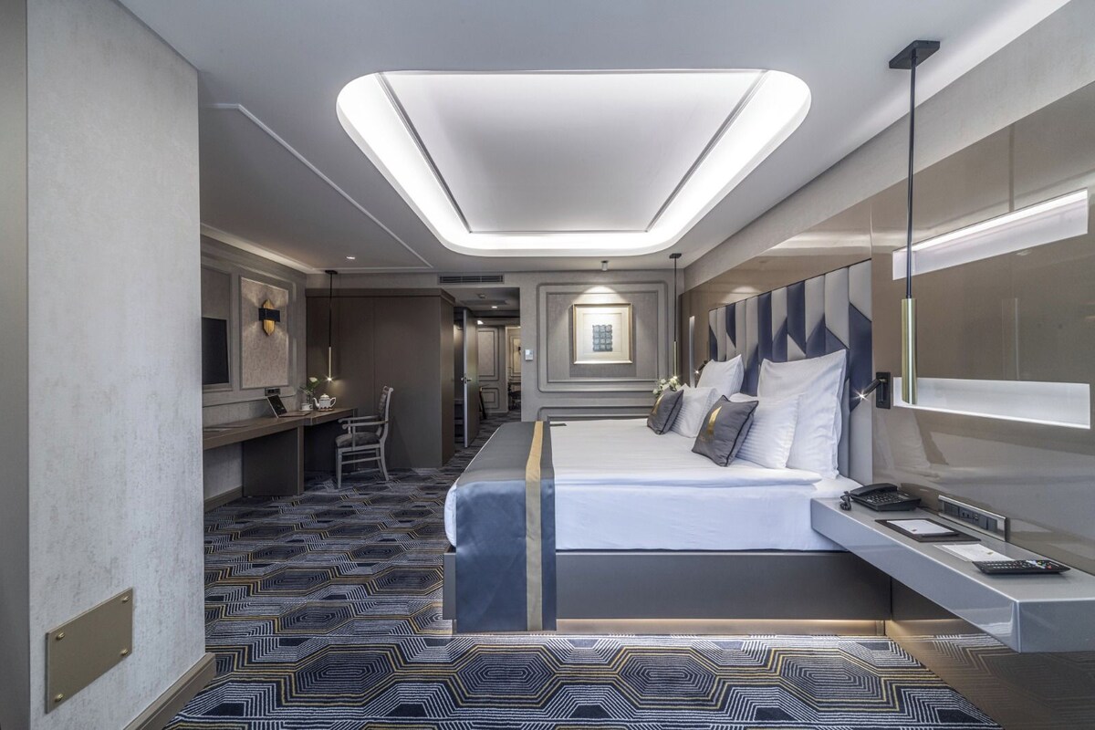 Ein modernes Hotelzimmer mit einem großen Bett, einem Schreibtisch und einer Sitzecke.