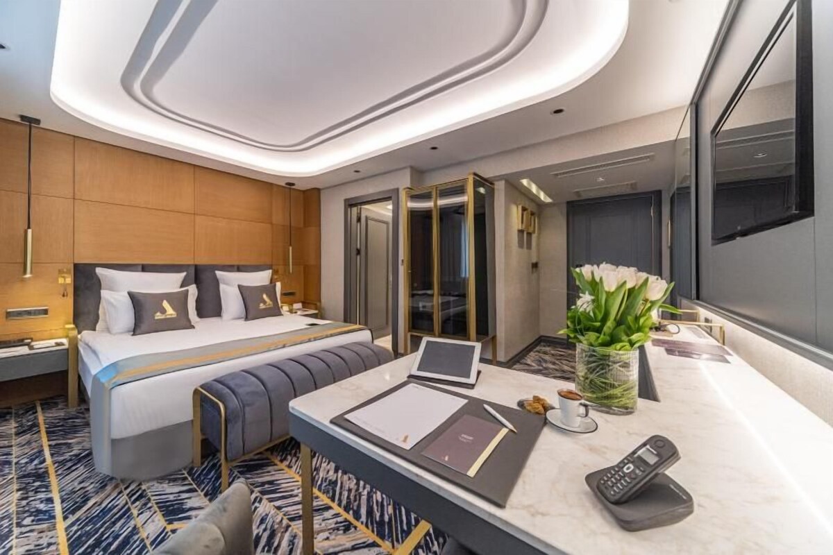 Ein modernes Hotelzimmer mit Bett, Schreibtisch und großem Fenster.
