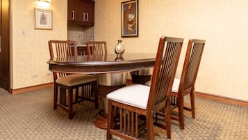 Comedor con mesa redonda rodeada de sillas de madera con asientos acolchados.