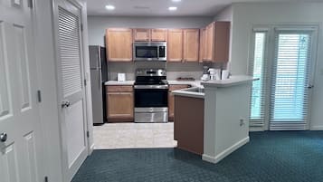 Una cocina moderna con armarios de madera, electrodomésticos de acero inoxidable y una isla central.