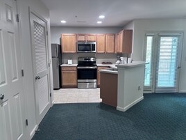 Una cocina moderna con armarios de madera, electrodomésticos de acero inoxidable y una isla central.