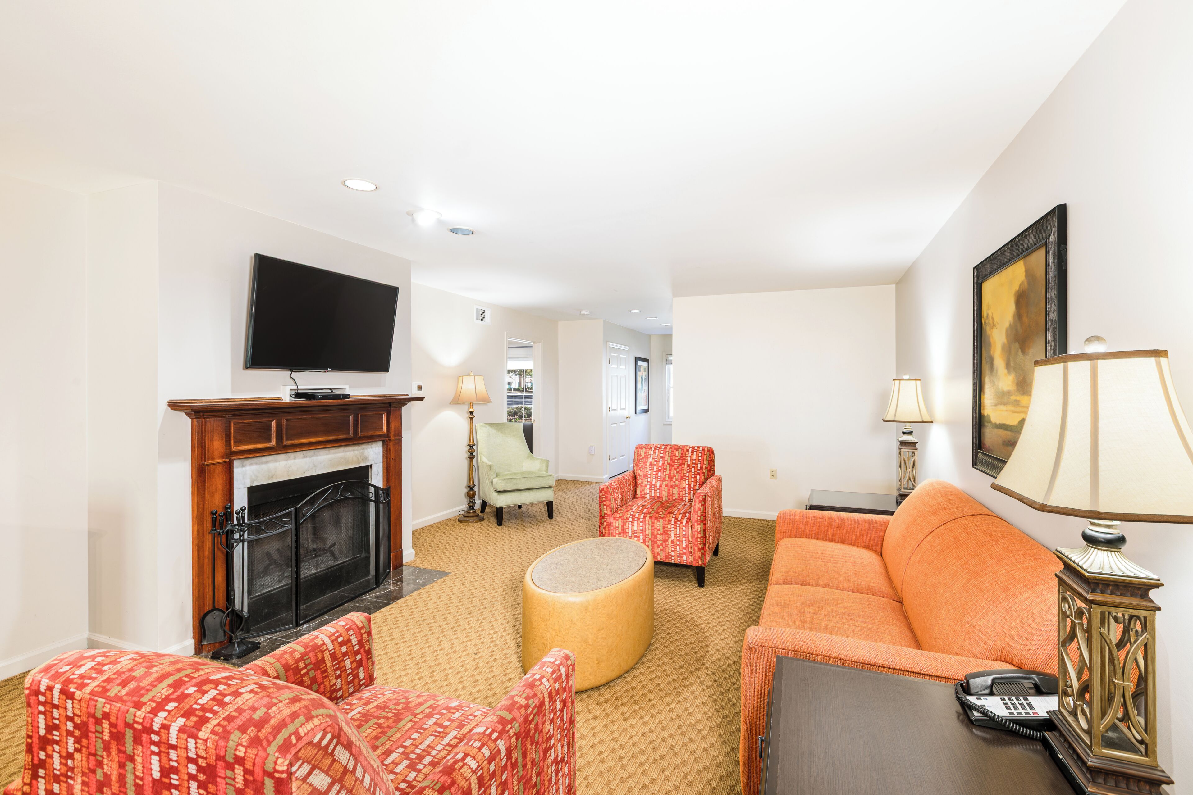 A living room with a fireplace, a television, a sofa, and a chair.