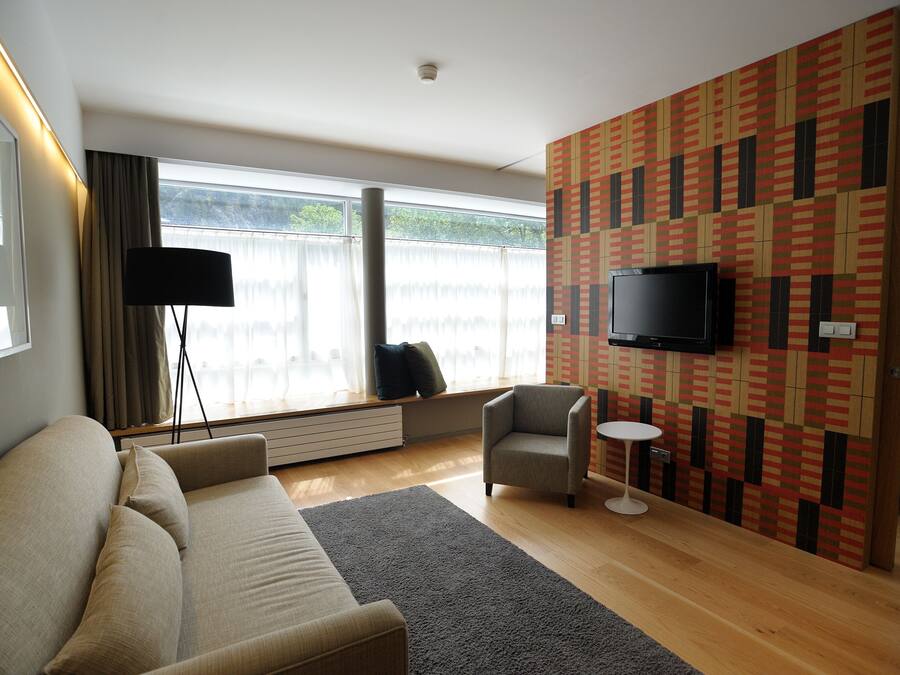 A modern living room with a sofa, armchair, and a small round table.