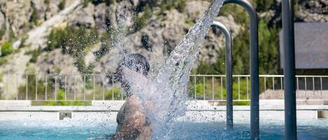 Una persona en una piscina rodeada de agua salpicando.