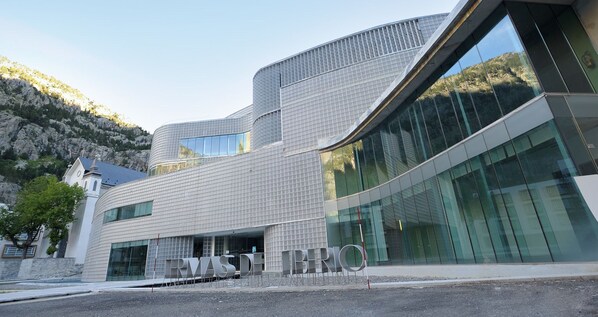A modern building with a unique curved facade and large glass windows. - Hotel Continental Balneario de Panticosa (Panticosa)