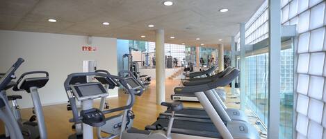 A gym with treadmills, elliptical machines, and exercise bikes.