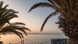 A pool area with a view of the sea, palm trees, and a clear sky. - Catalonia Punta del Rey (Candelaria)