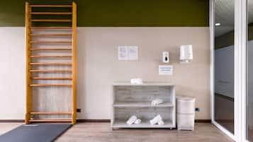 A room with a wooden ladder, a shelf with towels, a soap dispenser, and a sign indicating used towels.