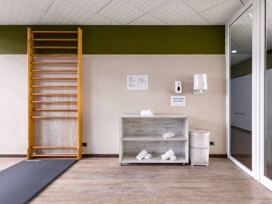 A room with a wooden ladder, a shelf with towels, a soap dispenser, and a sign indicating used towels.