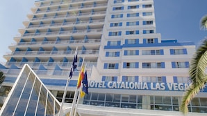Un hotel de varios pisos con balcones y una vista despejada del cielo.