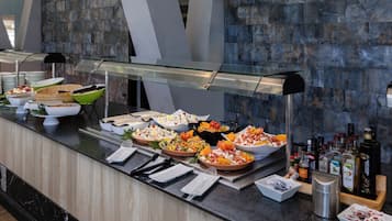 A buffet setup with various food items and condiments.