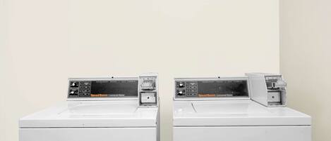 Two identical commercial washers with control panels, placed side by side against a plain wall.