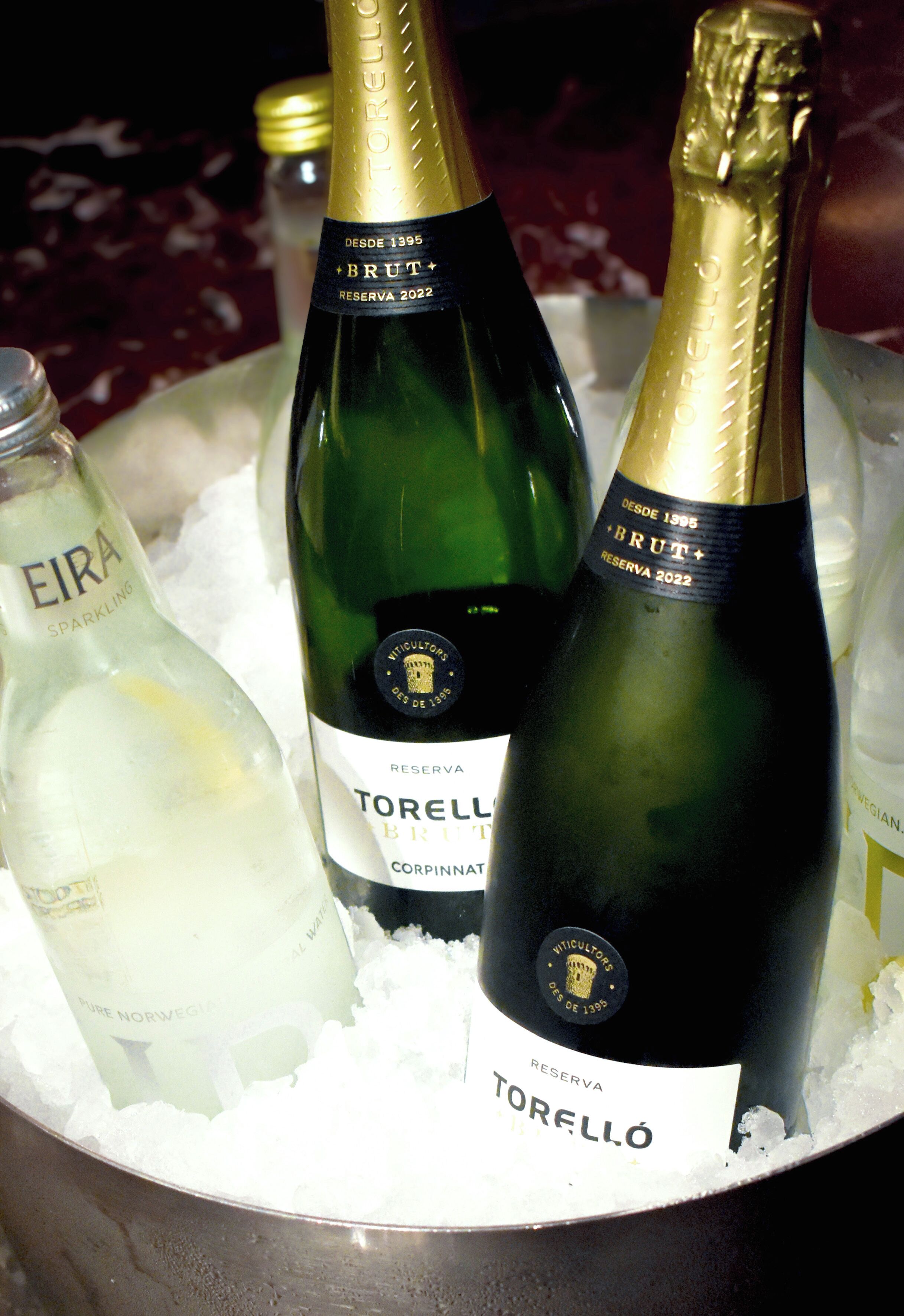 A container with bottles of Torreló wine and Eira sparkling wine on ice.