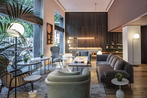 Uma sala de estar moderna com sofá, poltronas, mesa de centro e estante.