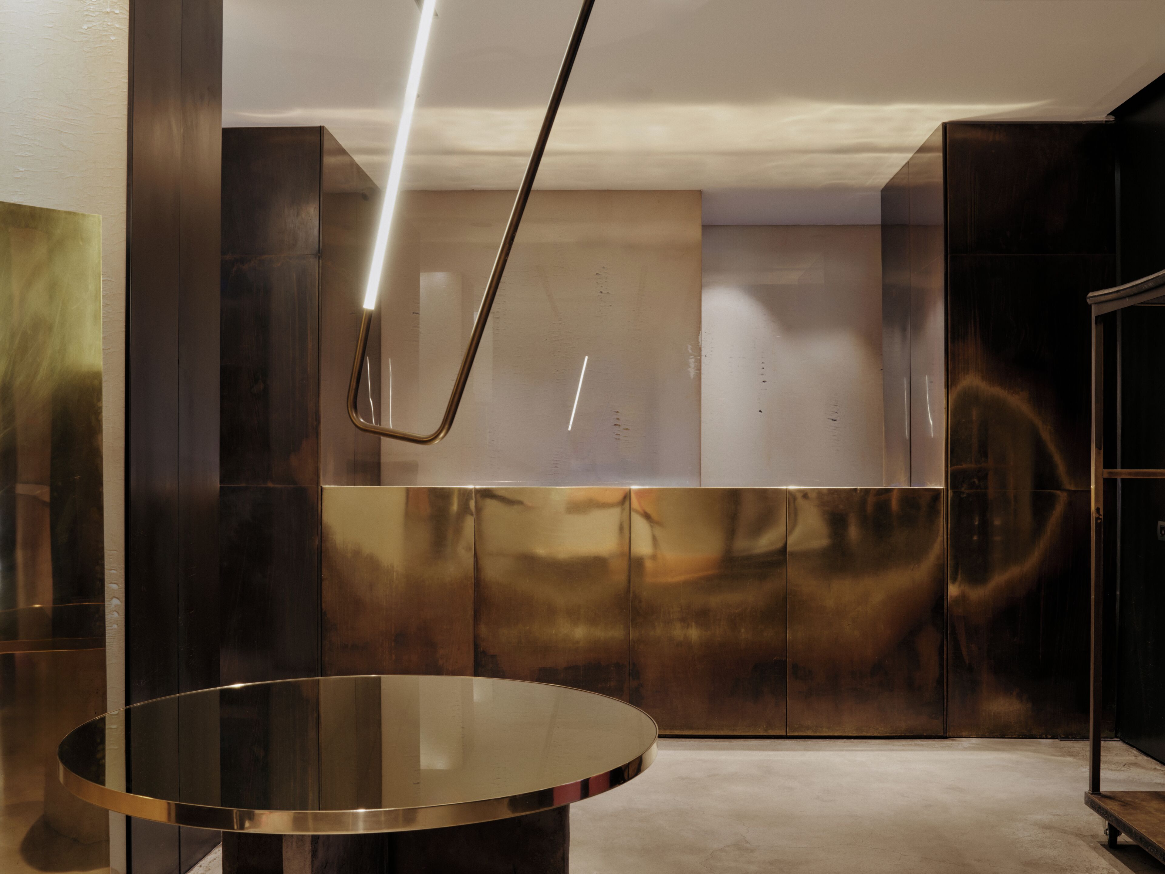 En modern inredning med ett metallbord, reflekterande ytor och en minimalistisk design.