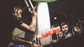 Un barista che versa bevande in bicchieri.