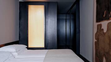 Una camera d'hotel moderna con un letto, un'ampia finestra e un'originale opera d'arte a parete.