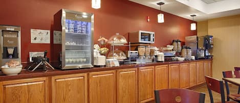 A breakfast bar with a coffee machine, a microwave, and a refrigerator.
