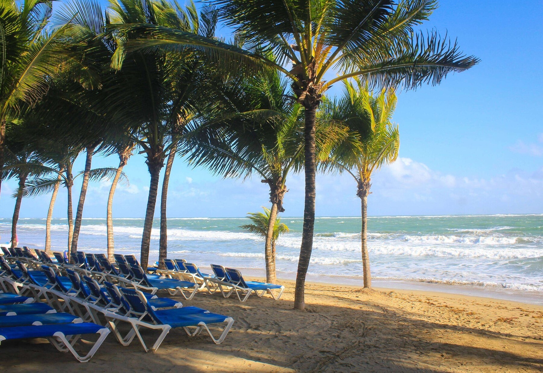 On the beach, white sand, sun-loungers, beach towels
