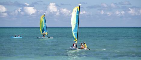 A sailboat with a large sail on the water.