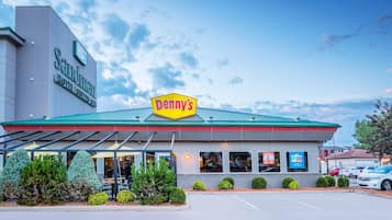 Un hôtel doté d’un toit végétalisé et d’une enseigne indiquant le restaurant « Denny’s ».
