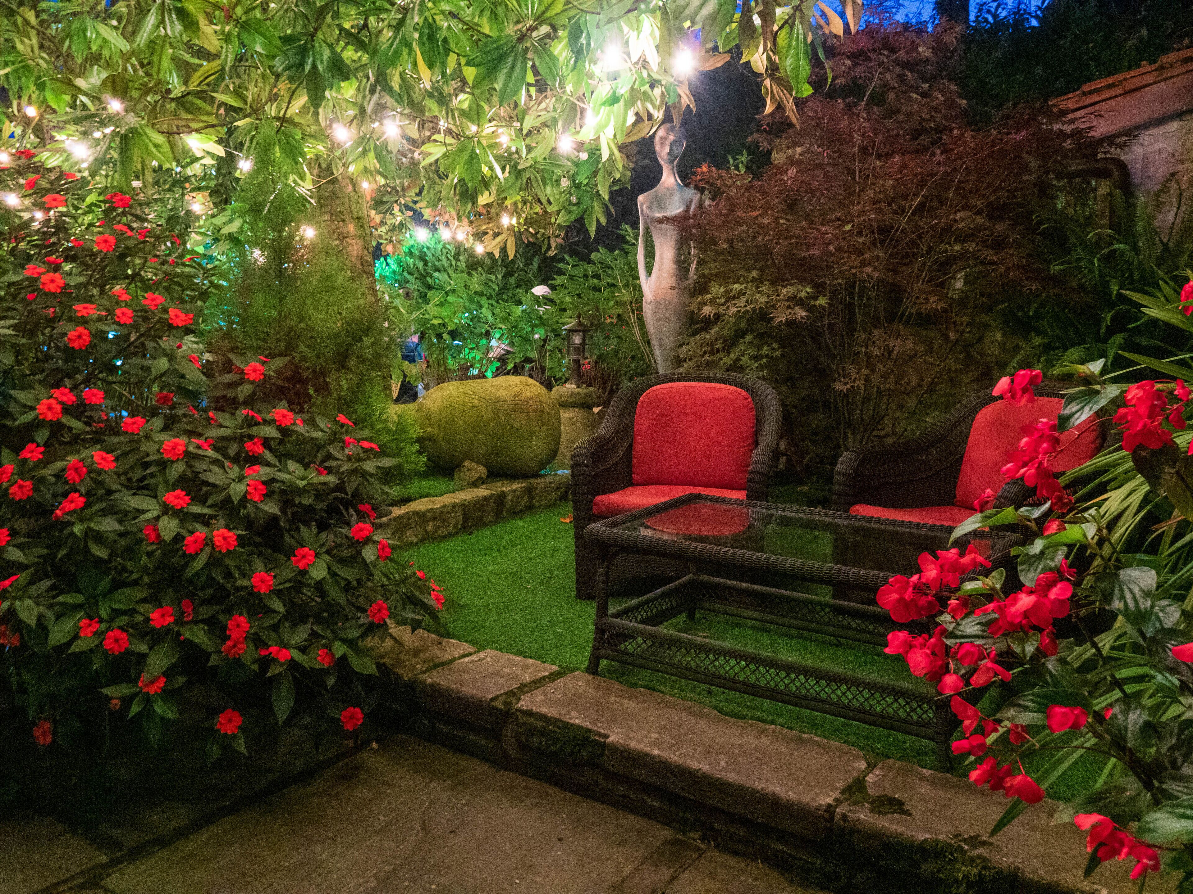 Ein Garten mit Korbmöbeln und einer Statue.